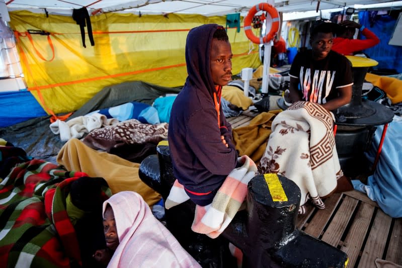 Migrants rest on board of NGO Proactiva Open Arms rescue boat in central Mediterranean Sea