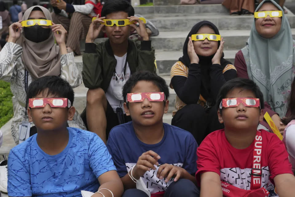 Niños usando gafas protectoras para ver un eclipse solar en Yakarta, Indonesia, en abril. (Tatan Syuflana/AP) (PRENSA ASOCIADA)