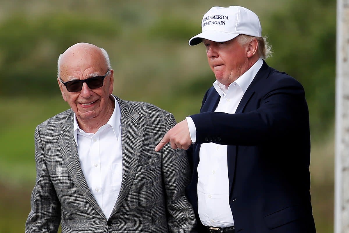 Donald Trump speaks to media mogul Rupert Murdoch as they walk out of Trump International Golf Links in Aberdeen, Scotland, June 25, 2016 (Reuters)