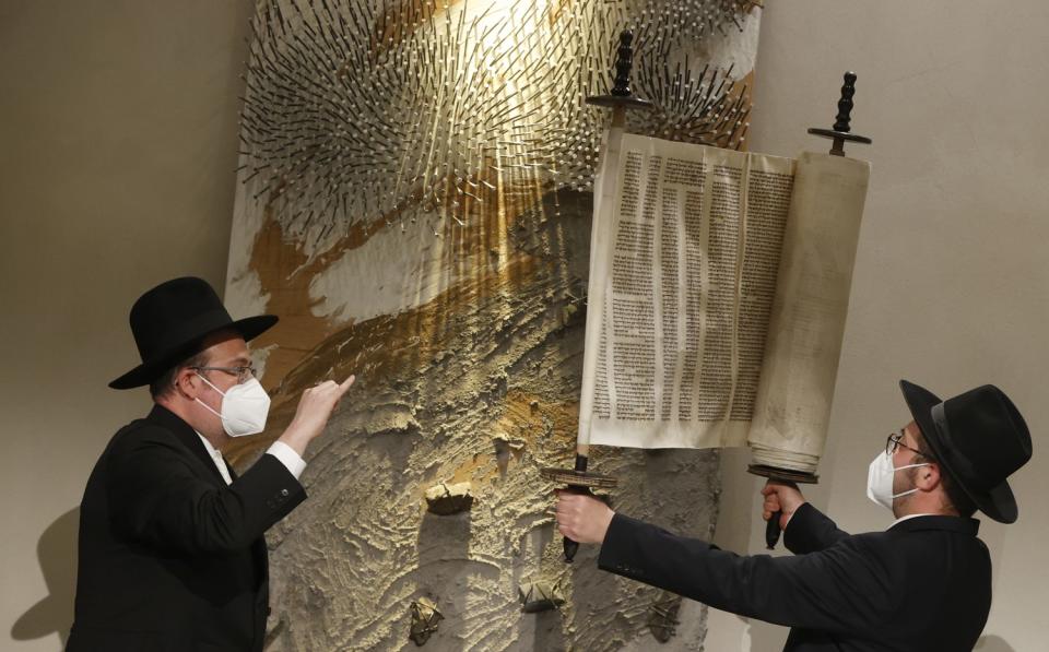 Rabbi Shaul Nekrich, right, holds the Sulzbach Torah Scroll in Berlin.