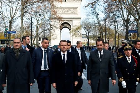 FILE PHOTO: French President Emmanuel Macron (centre) on a visit to the riot-battered neighbourhood around the Arc de Triomphe in Paris, December 2, 2018. Thibault Camus/Pool via REUTERS/File Photo