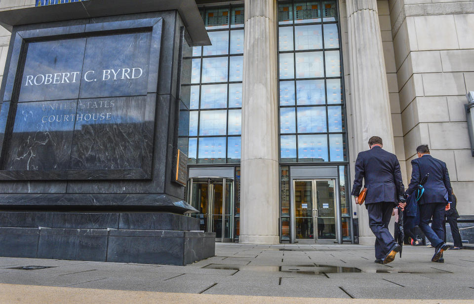 Huntington Mayor Steve Williams, left, and lawyer Rusty Webb enter the Robert C. Byrd United States Courthouse in Charleston, W. Va., Monday, May 3, 2021, for the start of the opioid trial. The trial is set to start in a lawsuit filed in West Virginia accusing three drug distributors of fueling a local opioid epidemic with excessively large shipments of painkillers over several years. (Kenny Kemp/Charleston Gazette-Mail via AP)