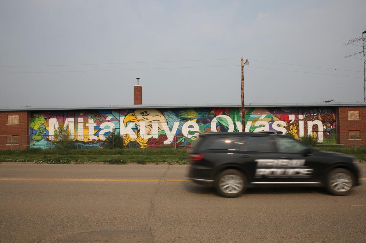 A tribal police car drives past a boarded up apartment complex on Main Street of Eagle Butte, South Dakota on the Cheyenne River Indian Reservation.