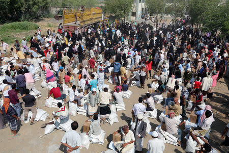 FILE PHOTO: Internally displaced people gather to collect food aid from an ICRC aid distribution centre in Bajil, Yemen, December 13, 2018, 2018. REUTERS/Abduljabbar Zeyad/File Photo