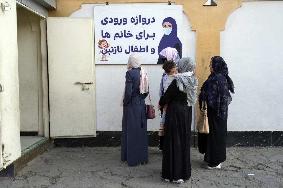 Afghan women stand outside an amusement park, in Kabul, Afghanistan on Nov. 10, 2022. The Taliban have banned women from using gyms and parks throughout the country.