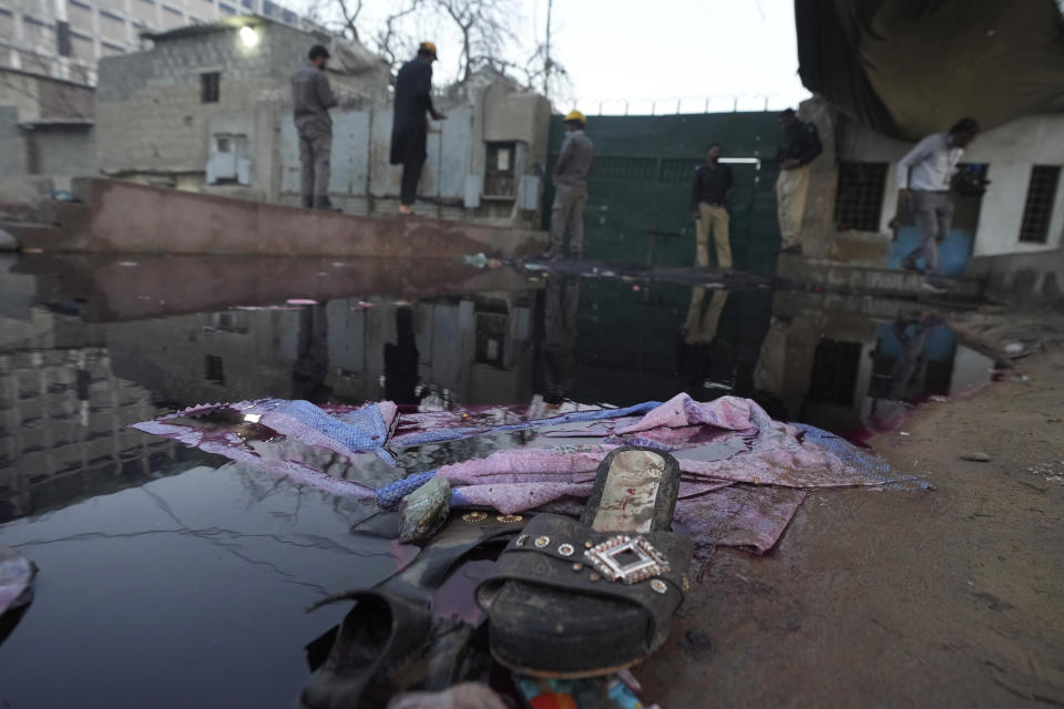 A tent and a pair of shoes of the victims are seen at the site of stampede, in Karachi, Pakistan, Friday, March 31, 2023. Several people were killed in the deadly stampede at a Ramadan food distribution center outside a factory in Pakistan's southern port city of Karachi, police and rescue officials said. (AP Photo/Fareed Khan)