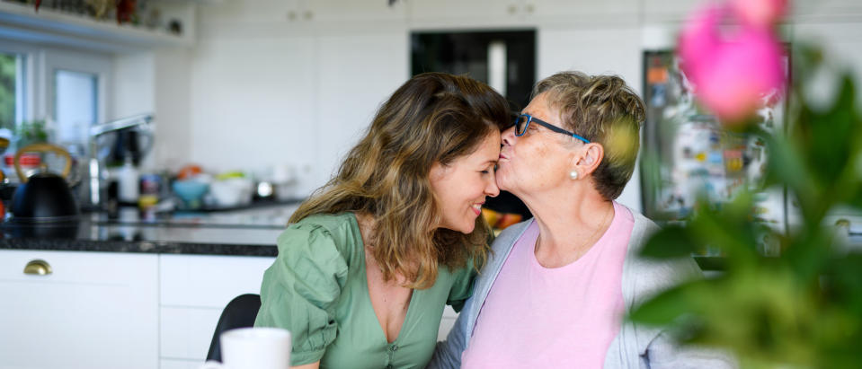 A mother kissing her daughter on the forehead