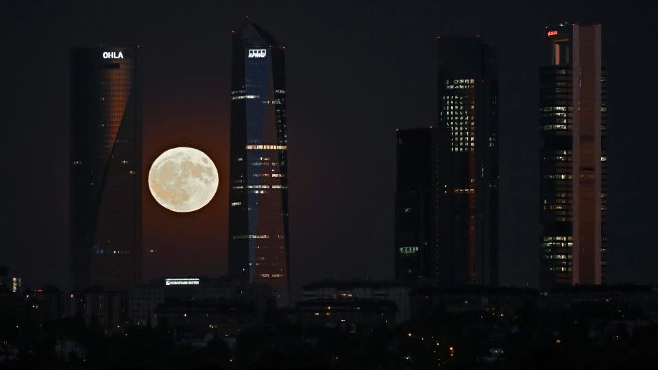 On August 1, 2023, a supermoon can be seen rising in the Cuatro Torres business district in Madrid.  -Javier Soriano/AFP/Getty Images