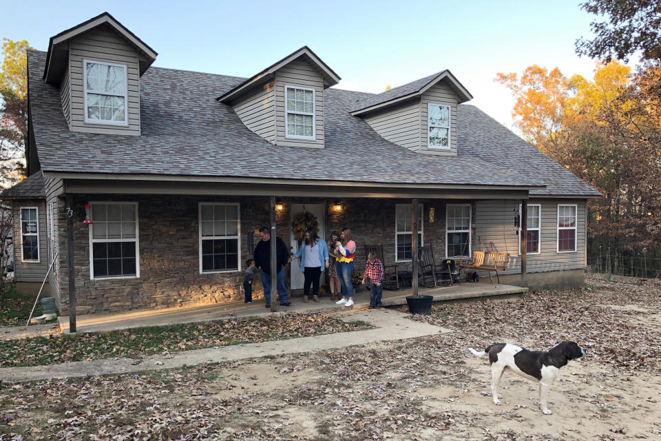 The Michael family gathers outside their home on Friday, Nov. 13, 2020, in Jonesboro, Ark. Among the victims of the coronavirus is Keith Michael's wife, fourth-grade Arkansas teacher Susanne Michael, who died less than three months after celebrating the adoption of three of the children. (AP Photo/Adrian Sainz)