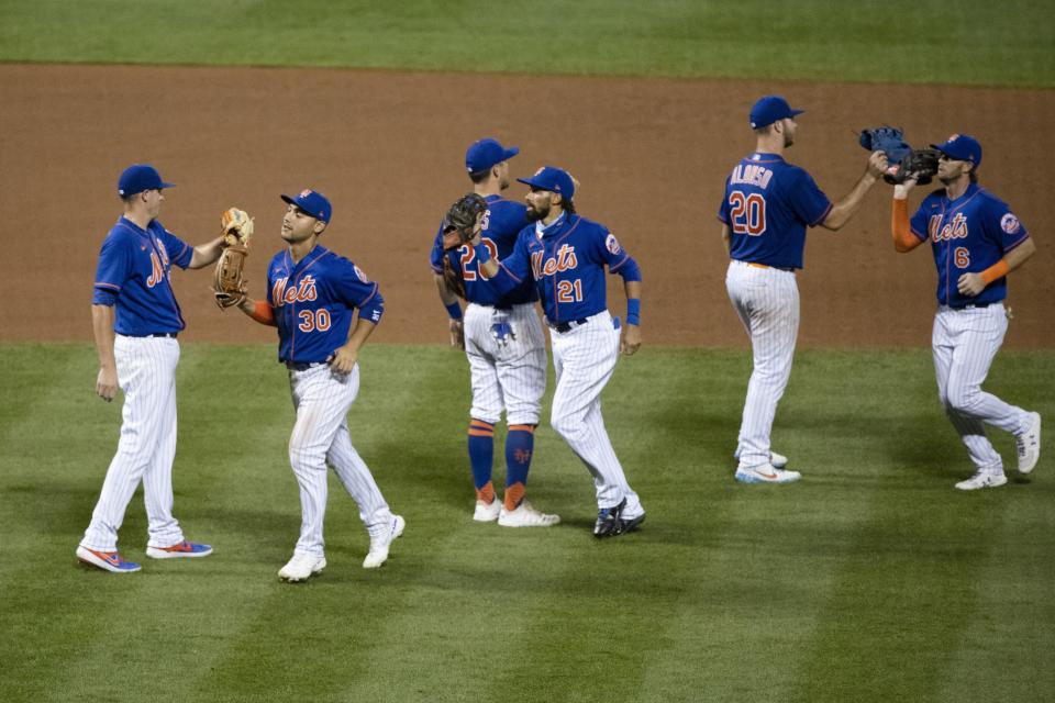 New York Mets' Michael Conforto (30), Billy Hamilton (21), and Jeff McNeil (6) celebrate with teammates after a baseball game against the Washington Nationals Wednesday, Aug. 12, 2020, in New York. The Mets won 11-6. (AP Photo/Frank Franklin II)