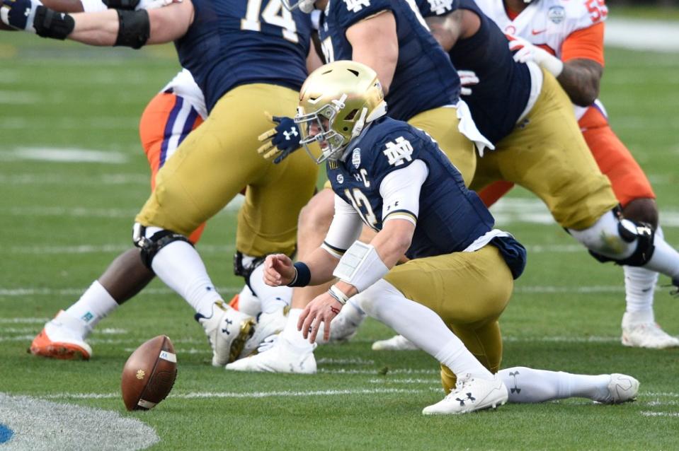 Dec 19, 2020; Charlotte, NC, USA; Notre Dame Fighting Irish quarterback Ian Book (12) reaches for a fumbled snap in the first quarter at Bank of America Stadium. Mandatory Credit: Bob Donnan-USA TODAY Sports