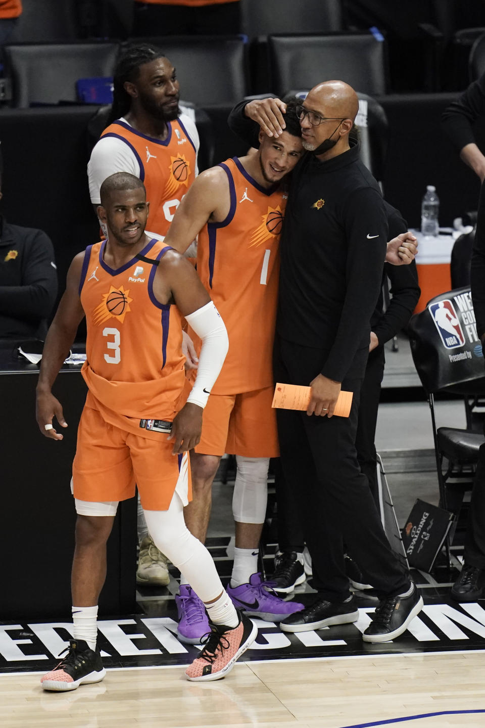 Phoenix Suns head coach Monty Williams, right, hugs Devin Booker as Chris Paul, left, walks past them in the final seconds of Game 6 of the NBA basketball Western Conference Finals Wednesday, June 30, 2021, in Los Angeles. (AP Photo/Jae C. Hong)