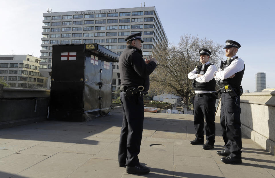 Police officers stand outside St Thomas' Hospital in central London as British Prime Minister Boris Johnson was moved to intensive care after his coronavirus symptoms worsened in London, Tuesday, April 7, 2020. Johnson was admitted to St Thomas' hospital in central London on Sunday after his coronavirus symptoms persisted for 10 days. Having been in hospital for tests and observation, his doctors advised that he be admitted to intensive care on Monday evening. The new coronavirus causes mild or moderate symptoms for most people, but for some, especially older adults and people with existing health problems, it can cause more severe illness or death.(AP Photo/Kirsty Wigglesworth)