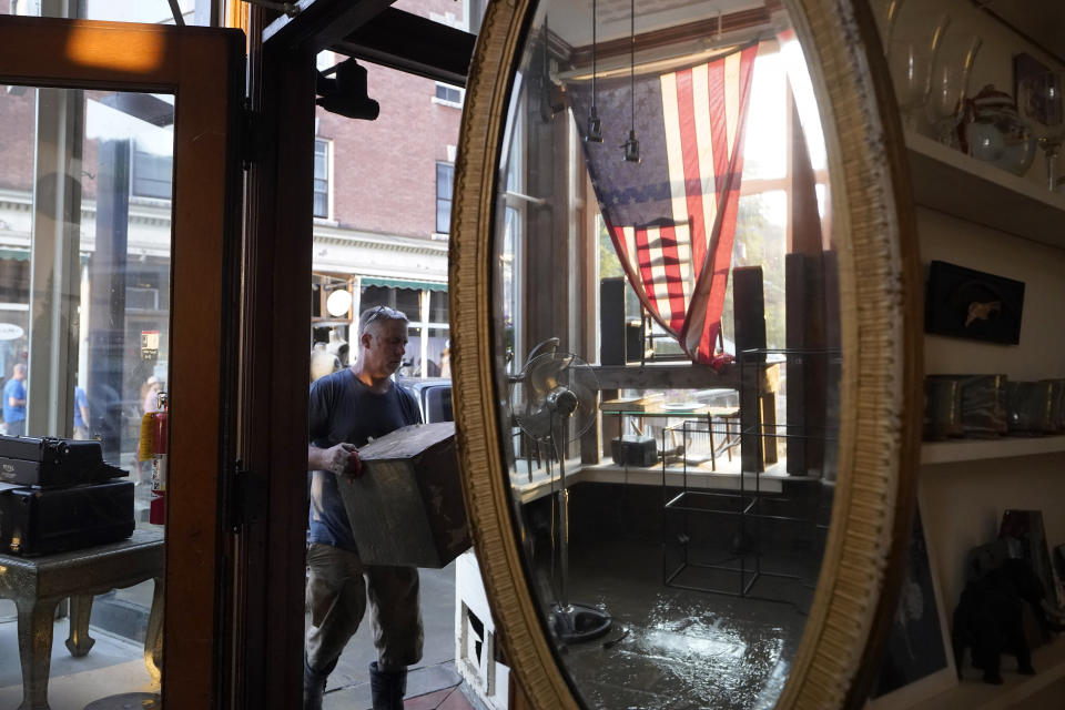 Simon Jennings, of Montpelier, Vt., removes furnishings and antiques from the flood-damaged store J. Langdon he shares with his wife in downtown Montpelier, Vt. Tuesday, July 11, 2023. A storm that dumped two months of rain in two days is brought more flooding across Vermont Tuesday. Flood waters rose to over three feet on the first floor of the store. (AP Photo/Steven Senne)