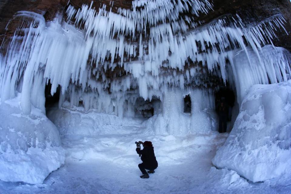 In this Feb. 2, 2014 photo people visit the caves at Apostle Islands National Lakeshore in northern Wisconsin, transformed into a dazzling display of ice sculptures by the arctic siege gripping the Upper Midwest. The caves are usually are accessible only by water, but Lake Superior’s rock-solid ice cover is letting people walk to them for the first time since 2009. (AP Photo/Minneapolis Star Tribune, Brian Peterson)