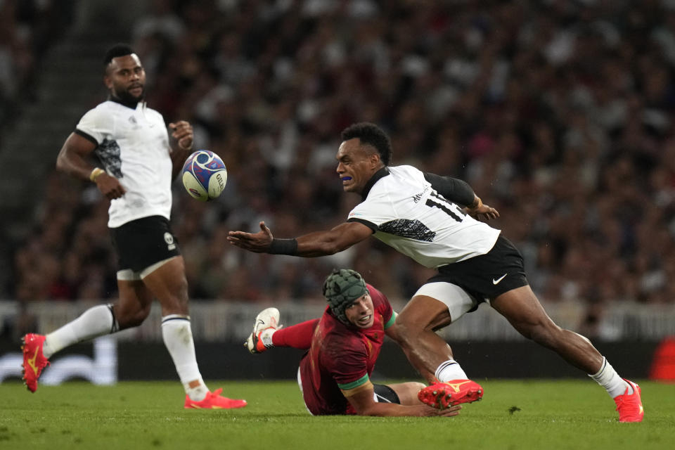 Fiji's Sireli Maqala, right, catches the ball as Portugal's Pedro Bettencourt watches on during the Rugby World Cup Pool C match between Fiji and Portugal, at the Stadium de Toulouse in Toulouse, France, Sunday, Oct. 8, 2023. (AP Photo/Pavel Golovkin)