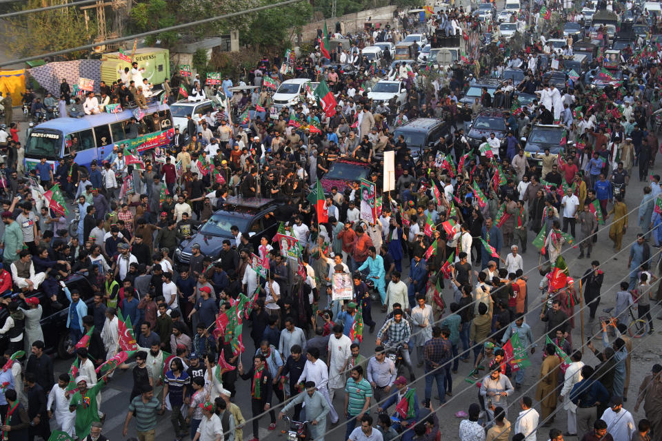 Supporters move with a convey of carrying Pakistan's former Prime Minister Imran Khan during an election campaign rally, in Lahore, Pakistan, Monday, March 13, 2023. Khan rallied thousands of supporters in eastern Pakistan on Monday as courts in the capital, Islamabad, issued two more arrest warrants for him over his failure to appear before judges in graft and terrorism cases, officials said. (AP Photo/K.M. Chaudary)