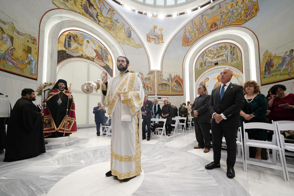 Konstantinos Loukas, center left, swings a censer during a service at St. Nicholas Greek Orthodox Church in New York, Tuesday, Dec. 6, 2022. After a rebuilding process that lasted more than two decades, the Greek Orthodox church that was destroyed in the Sept. 11 attacks has reopened at the World Trade Center site. The St. Nicholas Greek Orthodox Church and National Shrine, designed by architect Santiago Calatrava, now overlooks the Trade Center memorial pools from an elevated park. (AP Photo/Seth Wenig)