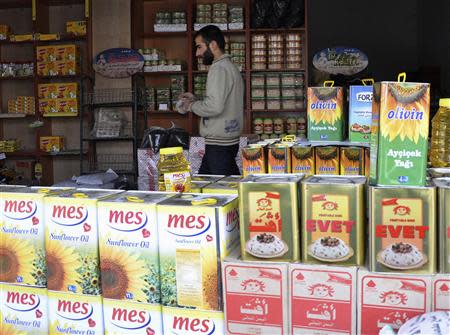 A man walks inside a shop in the town of Amuda, December 7, 2013. Picture taken December 7, 2013. REUTERS/Rodi Said