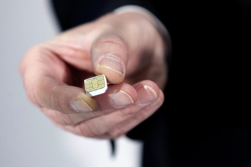 Gemalto CEO Olivier Piou shows a cell phone sim card before a press conference on February 25, 2015 in Paris. European SIM maker Gemalto said it had suffered hacking attacks that may have been conducted by US and British intelligence agencies but denied any 