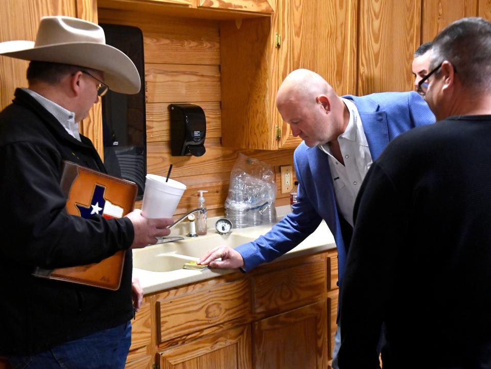 Taylor County District Attorney Investigator Shay Bailey draws from a deck of cards as he, Sheriff Ricky Bailey and Anson Police Officer Elias Carrasquillo Jr decide who would be first to speak in Friday’s sheriff’s debate.