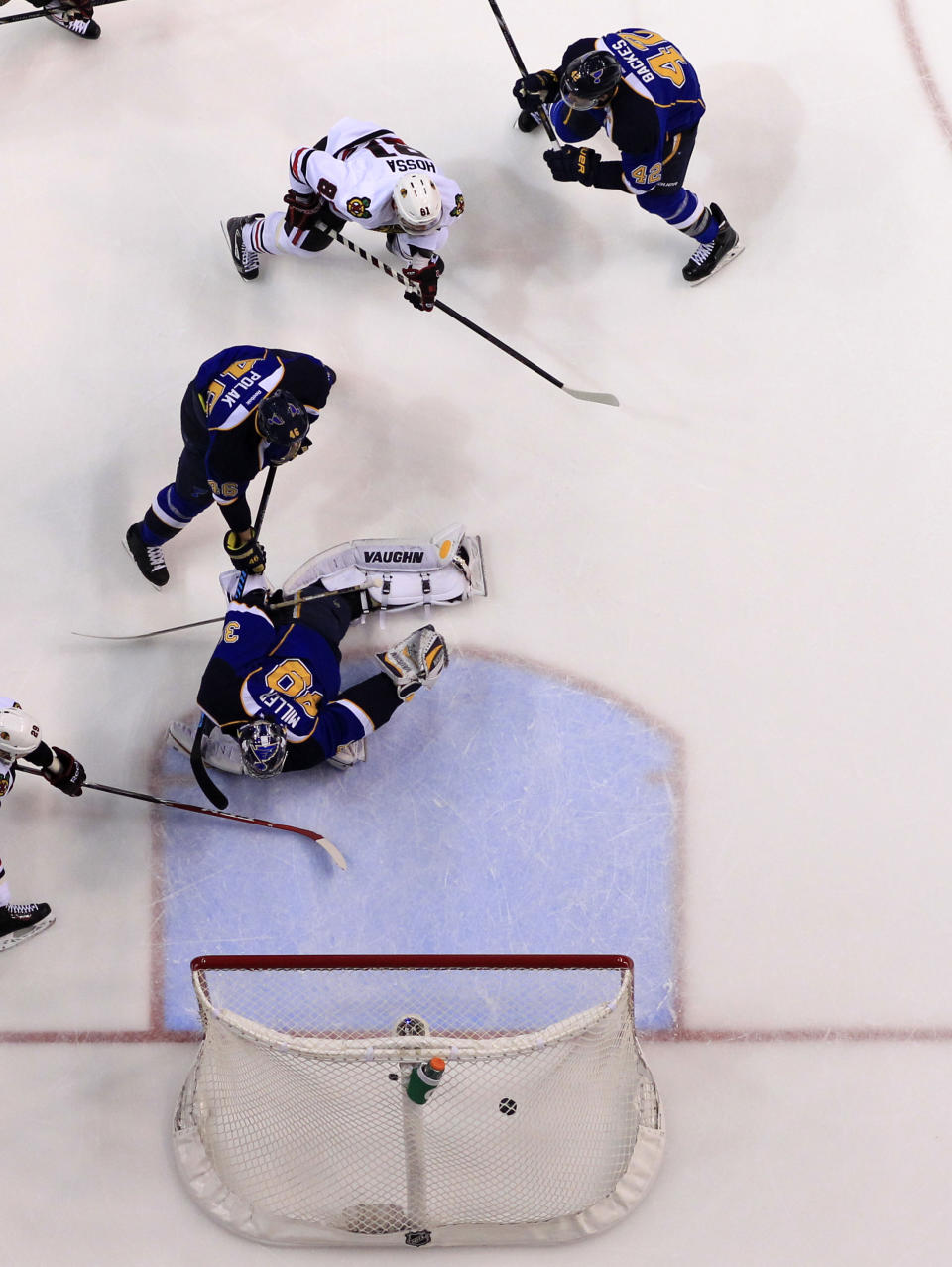 Chicago Blackhawks' Marian Hossa, top left, of Slovakia, scores past St. Louis Blues goalie Ryan Miller, bottom, Roman Polak, of the Czech Republic, and David Backes, top right, during the first period in Game 5 of a first-round NHL hockey playoff series Friday, April 25, 2014, in St. Louis. (AP Photo/Jeff Roberson)