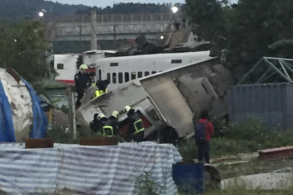 CORRECTS PLACE - In this photo released by Li Jun, rescue workers are seen at the site of a train derailment in Yilan county northeastern Taiwan on Sunday, Oct. 21, 2018. The Puyuma express train was carrying more than 300 passengers toward Taitung, a city on Taiwan's southeast coast, when it went off the tracks on Sunday afternoon. (Li Jun via AP)