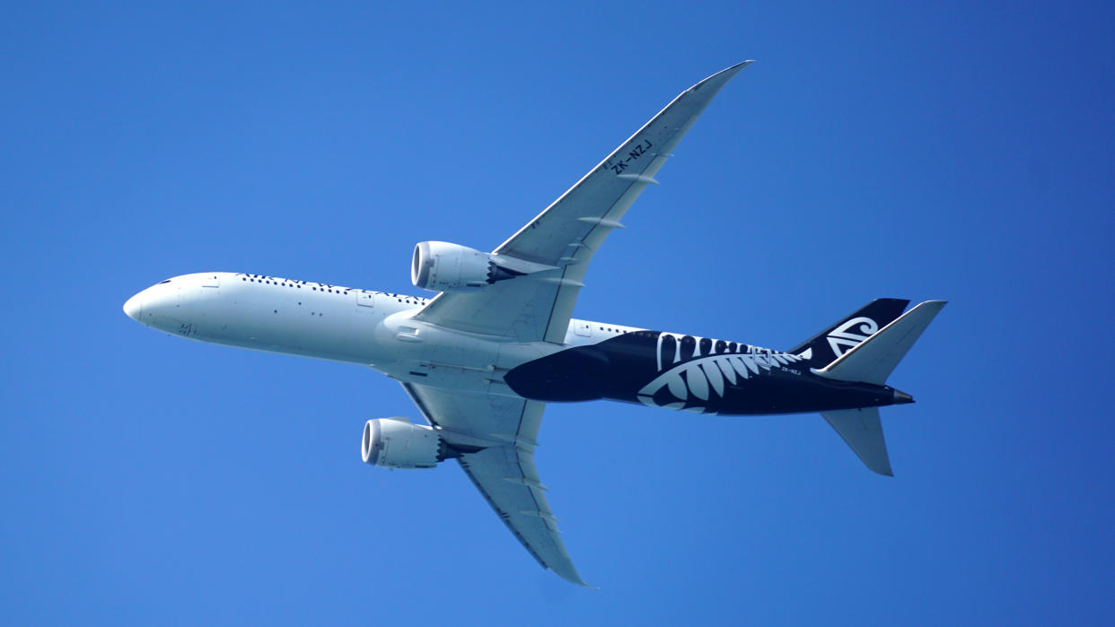 Looking up at an Air New Zealand Boeing 787-9 Dreamliner making its approach to Honolulu Airport.