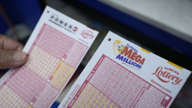 A lottery player holds forms to pick numbers for the Powerball and Mega Millions games.