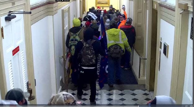 Lori Ann and Thomas Roy Vinson, of Morganfield, Kentucky, were both charged federally for entering the U.S. Capitol during the Jan. 6 riots. They're shown here in the Capitol Rotunda on the 2nd floor; Thomas Vinson in an orange jacket and cap.