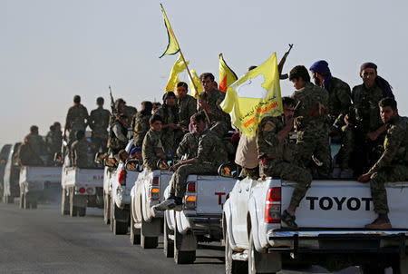 Fighters of Syrian Democratic Forces ride on trucks as their convoy passes in Ain Issa, Syria October 16, 2017. REUTERS/Erik De Castro