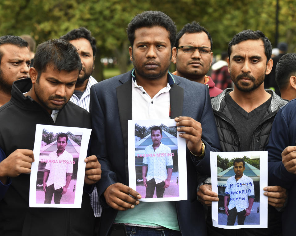 Friends of a missing man Zakaria Bhuiyan hold up photos of him outside a refuge center in Christchurch, Sunday, March 17, 2019. The live-streamed attack by an immigrant-hating white nationalist killed dozens of people as they gathered for weekly prayers in Christchurch. (Mick Tsikas/AAP Image via AP)