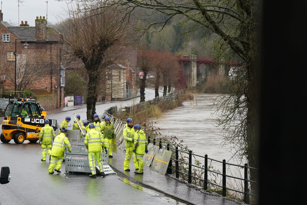 The River Severn has risen, causing flood defences to be put in place along the wharf at Ironbridge (PA)