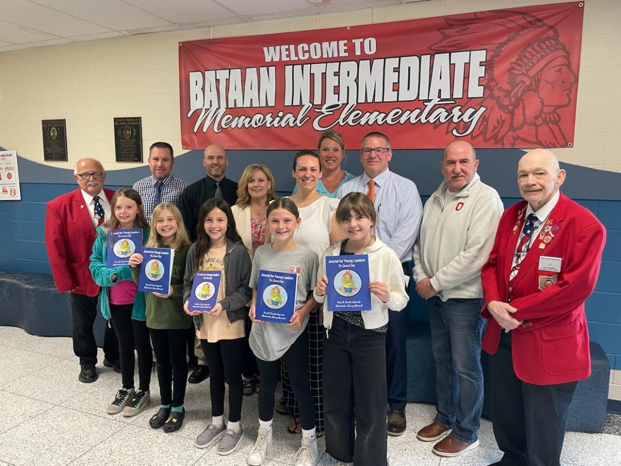 Fourth-grade students at Bataan Memorial Intermediate display copies of "Journal for Young Readers" written by Tony and Sandy Legando and donated to the school by the Port Clinton Elks Lodge 1718. Students, from left in the front row, are Kadence Price, Lyllie Nelson, Brynn Kozlok, Iris Wiechman, and Addison Hicks. In the back row, from left, are Marv Solomon, Kevin Belden, Brett Reineck, Nicole Heilmann, Melissa Frisch, Kerri Ziegler, Geoff Halsey, Tony Legando, and Bill Murphy.