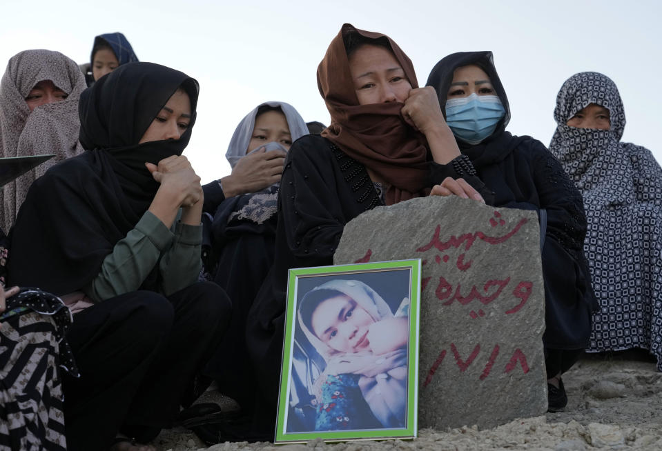 The family of 20-year-old Vahida Heydari, who was a victim of a suicide bombing on a Hazara education center, mourns over her grave, in Kabul, Afghanistan, Sunday, Oct. 2, 2022. Last week’s suicide bombing at the Kabul education center killed as many as 52 people, more than double the death toll acknowledged by Taliban officials, according to a tally compiled by The Associated Press on Monday. (AP Photo/Ebrahim Noroozi)