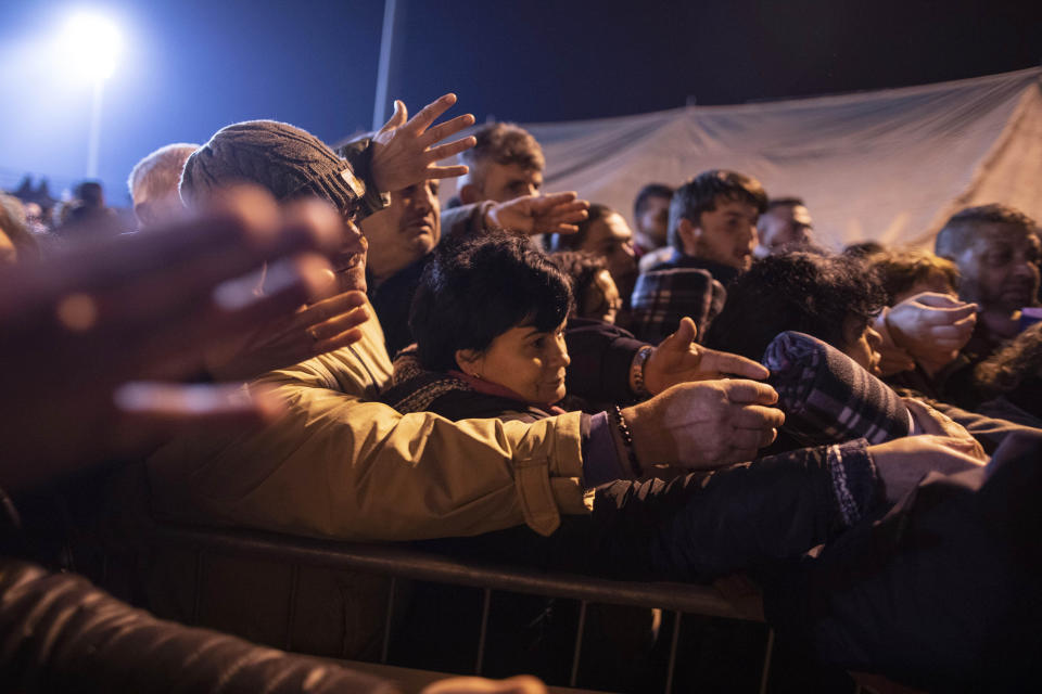 People gather to receive blankets provided by volunteers at a makeshift camp in a soccer field, following a deadly earthquake in Durres, Albania, on Tuesday, Nov. 26, 2019. (AP Photo/Petros Giannakouris)