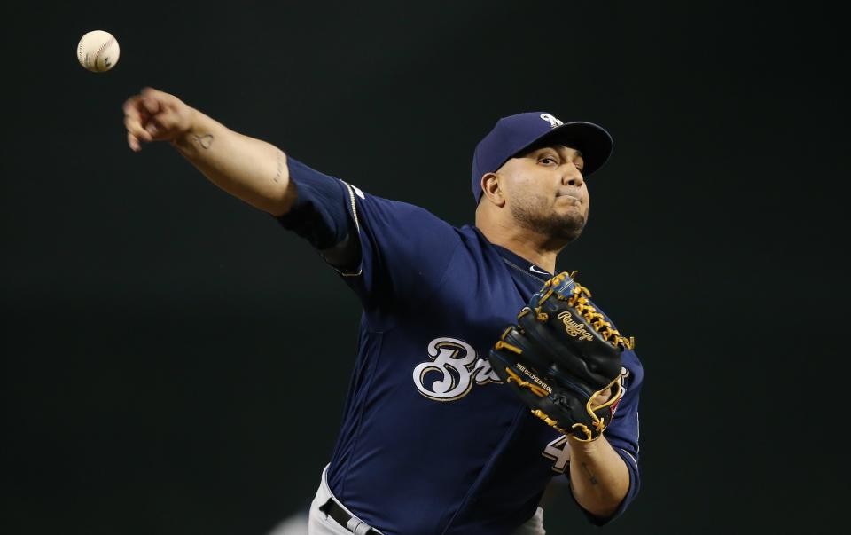 FILE - In this July 19, 2019 file photo, Milwaukee Brewers starting pitcher Jhoulys Chacin warms up during the first inning of a baseball game against the Arizona Diamondbacks, in Phoenix. Chacin helped buy plane tickets for a young Venezuelan team to compete in a tournament in Mexico, which they went on to win. It was a bright spot for a country more accustomed to news about political conflict and economic turmoil. (AP Photo/Ross D. Franklin, File)