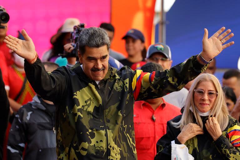 El presidente Nicolás Maduro, acompañado por la primera dama Cilia Flores, saluda a sus partidarios durante un evento en Caracas, Venezuela, el 23 de enero de 2024. (Foto AP/Jesús Vargas)