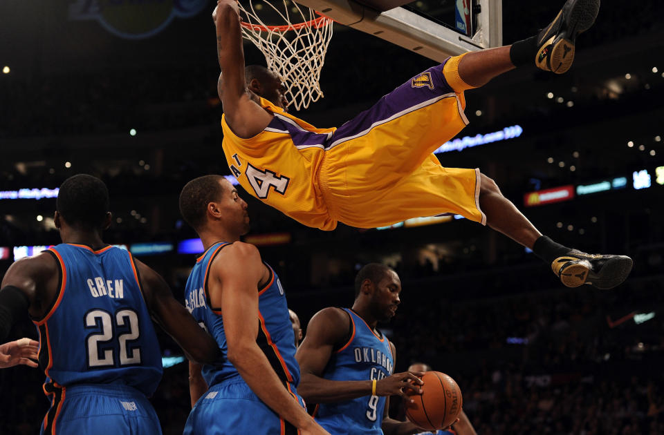 Bryant&nbsp;hangs on to the rim after a Jan. 17, 2011, dunk against the Oklahoma City Thunder.