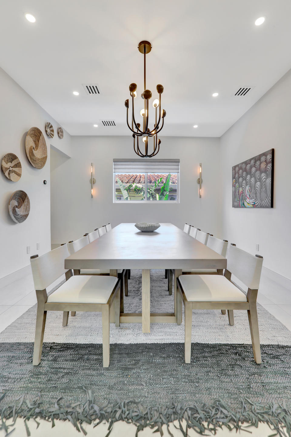 Neutral dining room with rectangular table and statement light fitting.