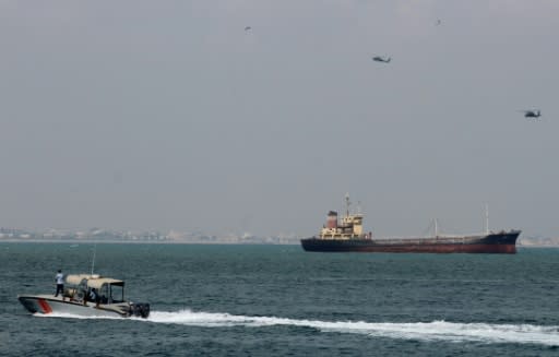 Military helicopters fly over a ship as it arrives in the southern Yemeni port of Aden on October 29, 2018