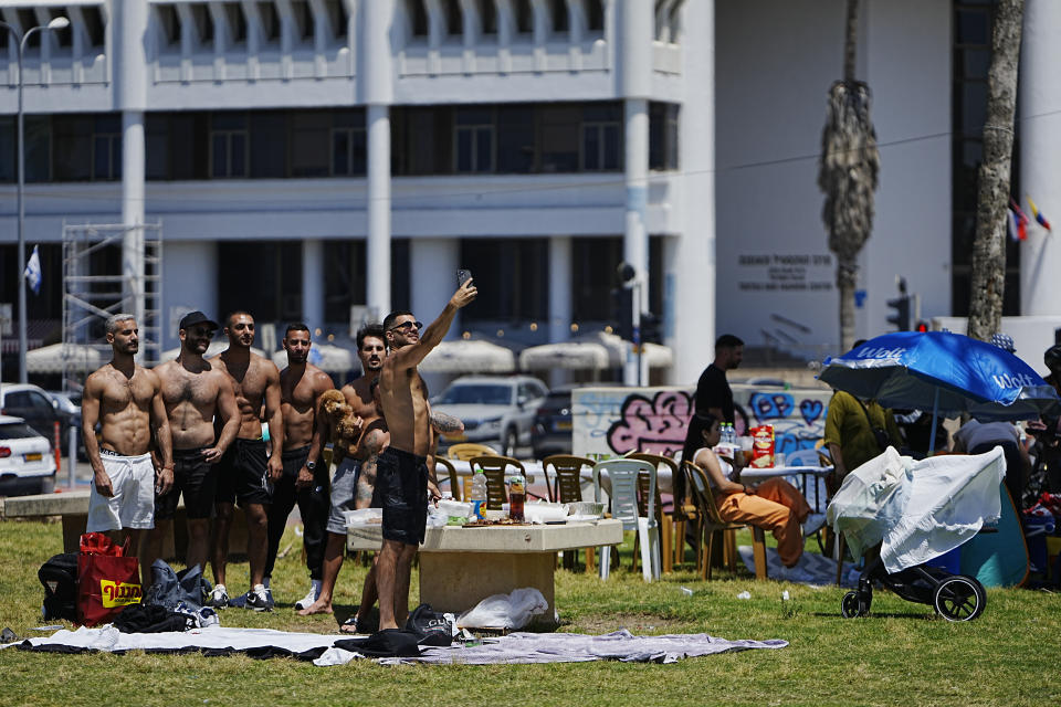 People pose for a selfie in a park during Israel's Independence Day celebrations in Tel Aviv, Tuesday, May 14, 2024. Israelis are marking 76 years since Israel's creation. (AP Photo/Ohad Zwigenberg).