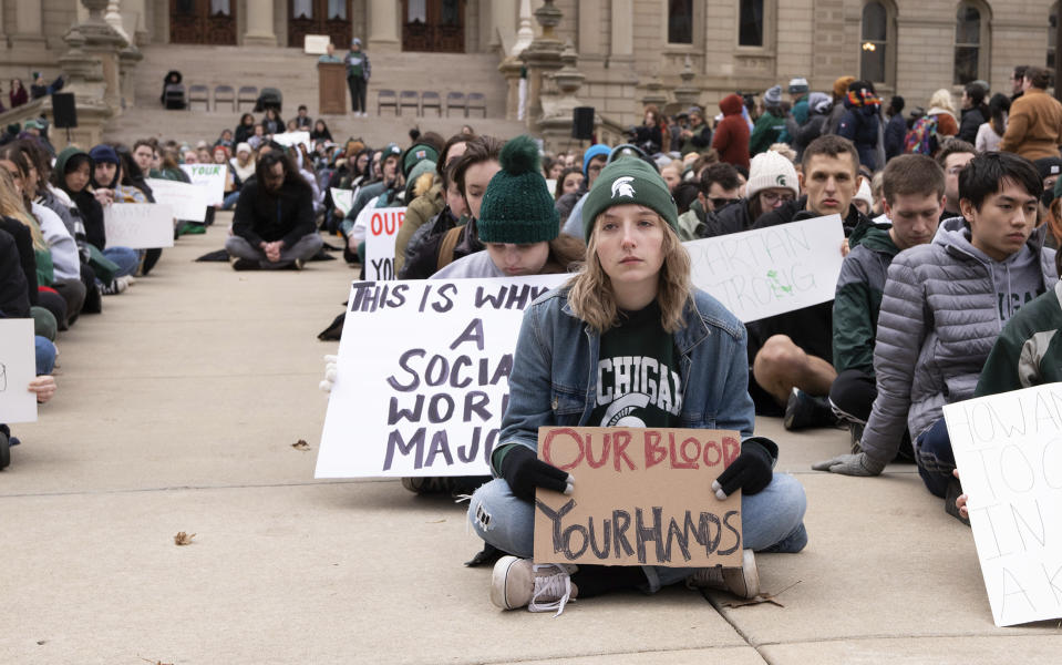 Protesters hold signs to protest gun violence at a student sit in at the Michigan Capitol building following a mass shooting at Michigan State University earlier in the week,in Lansing, Mich., on Wednesday, Feb. 15, 2023. (Brice Tucker/The Flint Journal via AP)