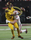 Arizona State quarterback Jayden Daniels (5) throws the ball away before getting taken down by Wisconsin linebacker Jack Sanborn (57) during the second half of the Las Vegas Bowl NCAA college football game Thursday, Dec. 30, 2021, in Las Vegas. (AP Photo/L.E. Baskow)