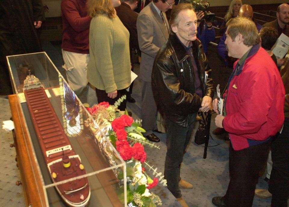 A model of the SS Edmund Fitzgerald is seen next to singer-songwriter Gordon Lightfoot, left, as he talks to Darrell Walton of Toledo, Ohio, right, after a memorial service commemorating the 25th anniversary of the sinking of the ship at the Mariner's Church of Detroit on Nov. 12, 2000. Lightfoot's song "Wreck of the Edmund Fitzgerald" immortalized the sinking of the ship, which went down in Lake Superior on Nov. 10, 1975. All 29 crew members, including Walton's uncle Ralph Grant Walton, went down with the ship.