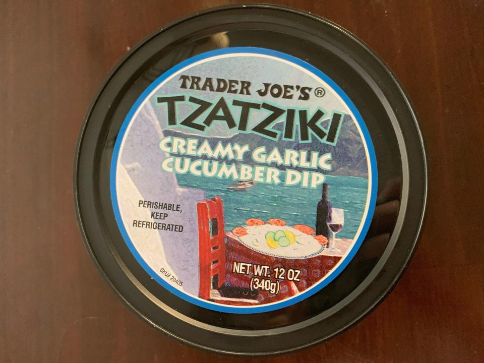 multicolored tub of trader joe's tzatziki on wood table