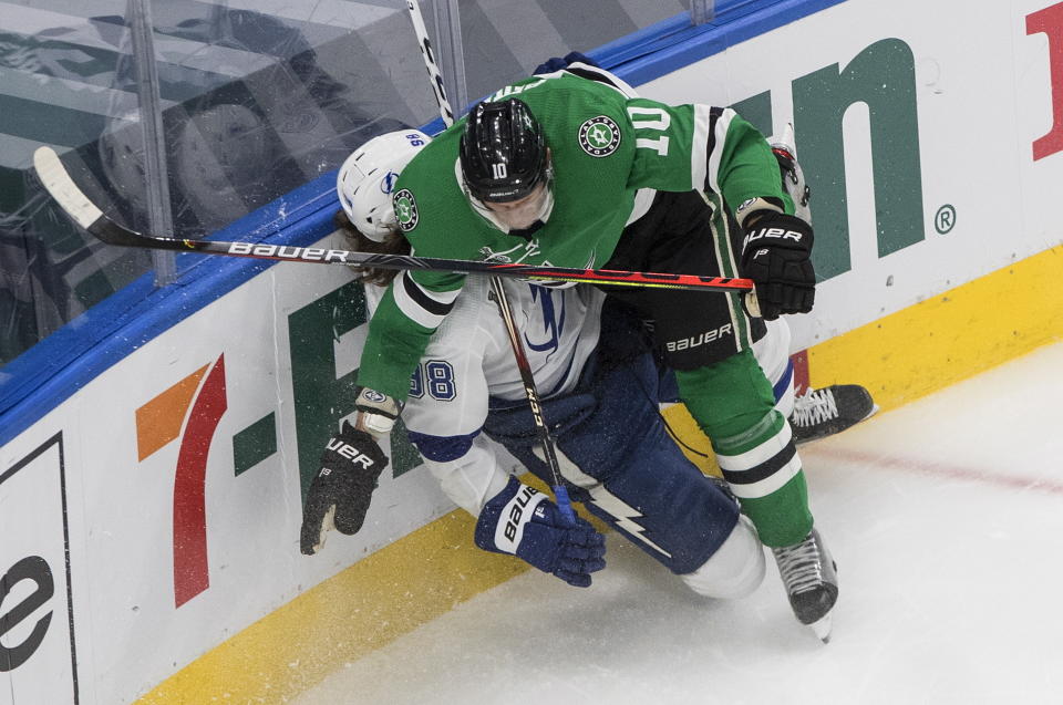 Tampa Bay Lightning's Mikhail Sergachev (98) is checked by Dallas Stars' Corey Perry (10) during first-period NHL Stanley Cup finals hockey game action in Edmonton, Alberta, Monday, Sept. 28, 2020. (Jason Franson/The Canadian Press via AP)