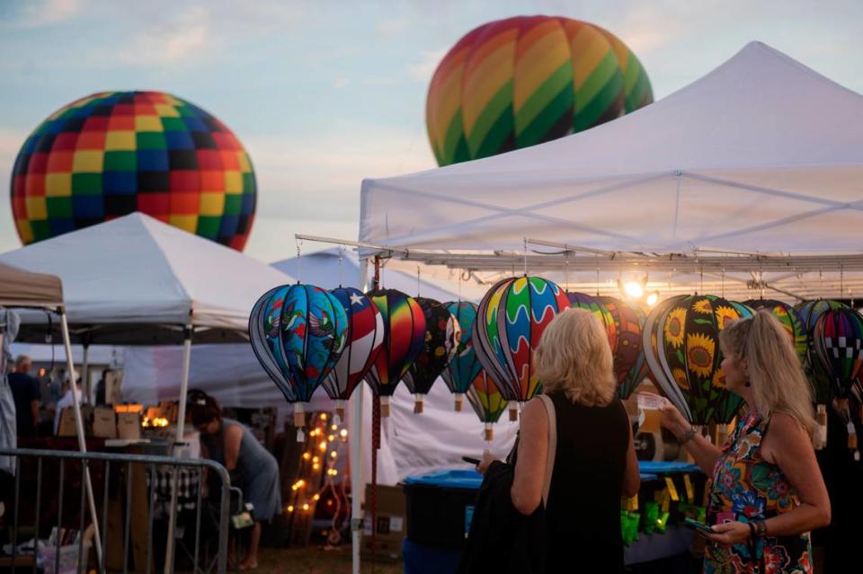 Festival attendees shop for hot air balloon themed merchandise during the Gulf Coast Hot Air Balloon Festival at OWA in Foley, Alabama on Thursday, May 4, 2023.