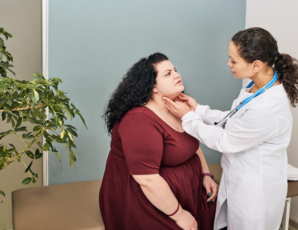 doctor checking a woman's thyroid gland