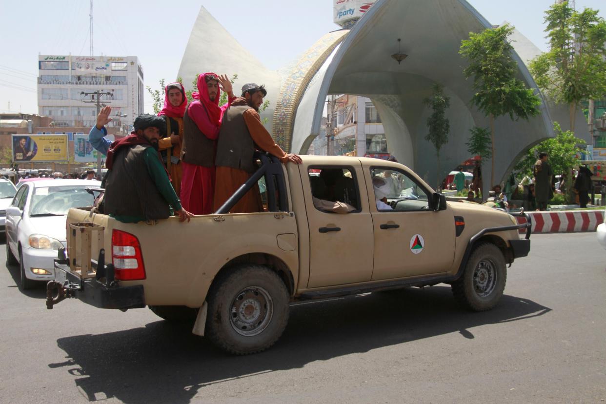 Taliban fighters pose on the back of a vehicle in the city of Herat, west of Kabul, Afghanistan on Saturday, Aug. 14, 2021, after they took this province from the Afghan government. The Taliban seized two more provinces and approached the outskirts of Afghanistan’s capital.